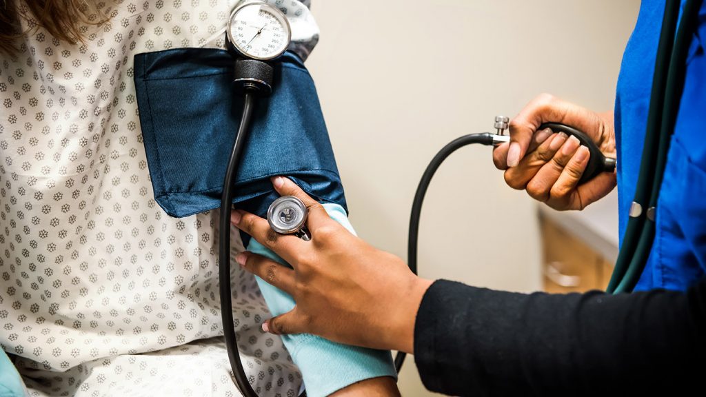 A healthcare professional checks a patient’s blood pressure